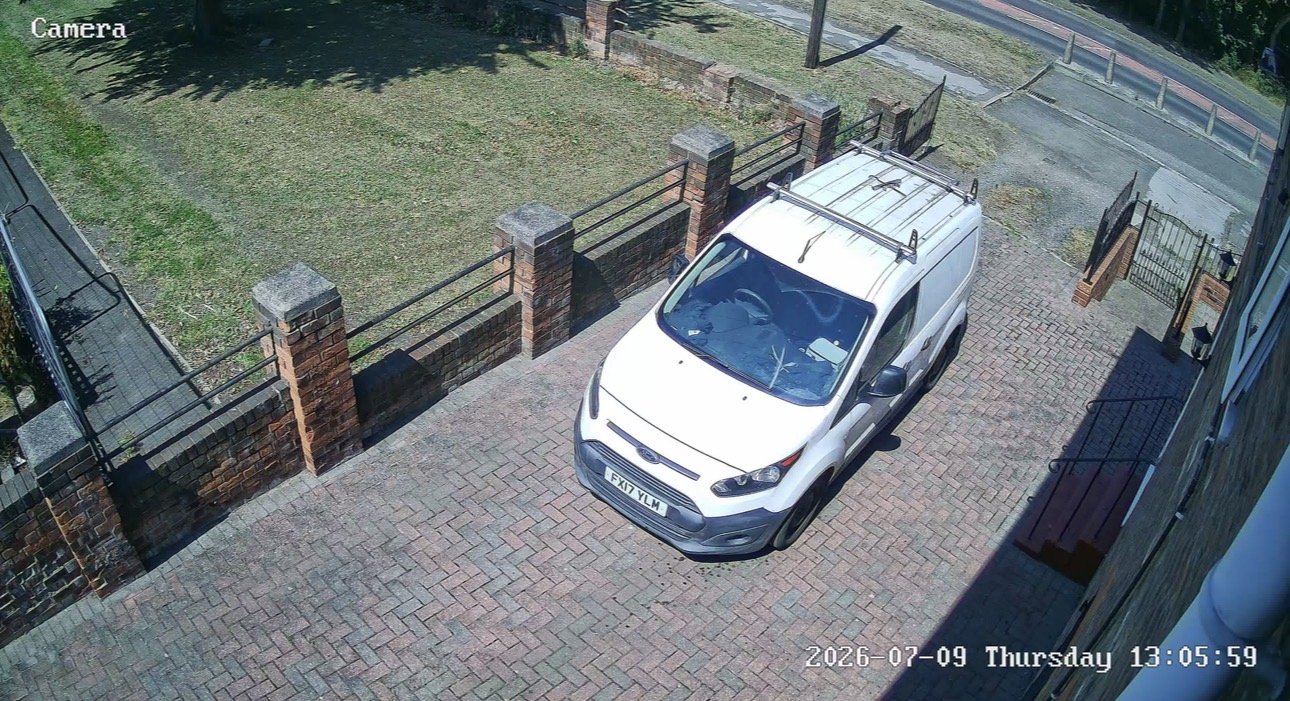 CCTV camera covering a brick-paved driveway with a parked white van, installed by L&B Security