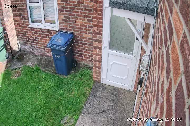 Redcar CCTV camera view of a side passage with a white door and wheelie bin