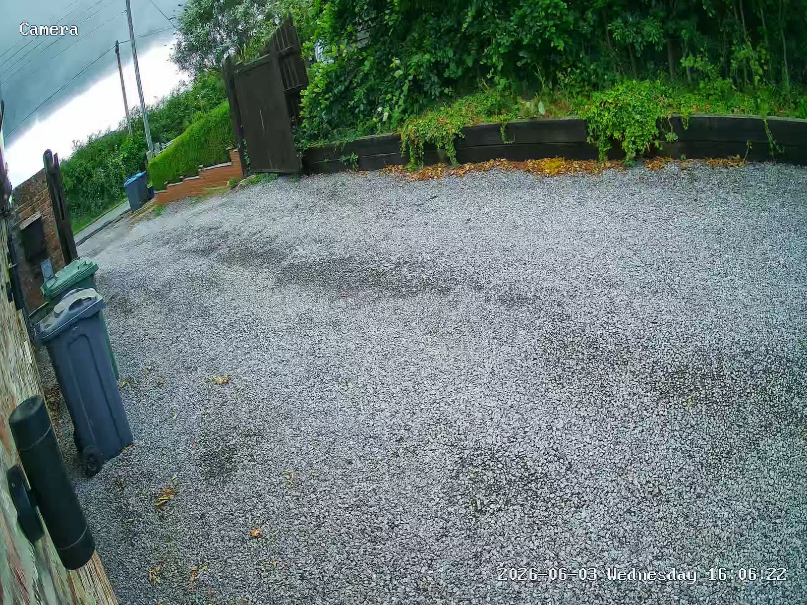 Billingham CCTV camera view of a gravel driveway with a gate and bins