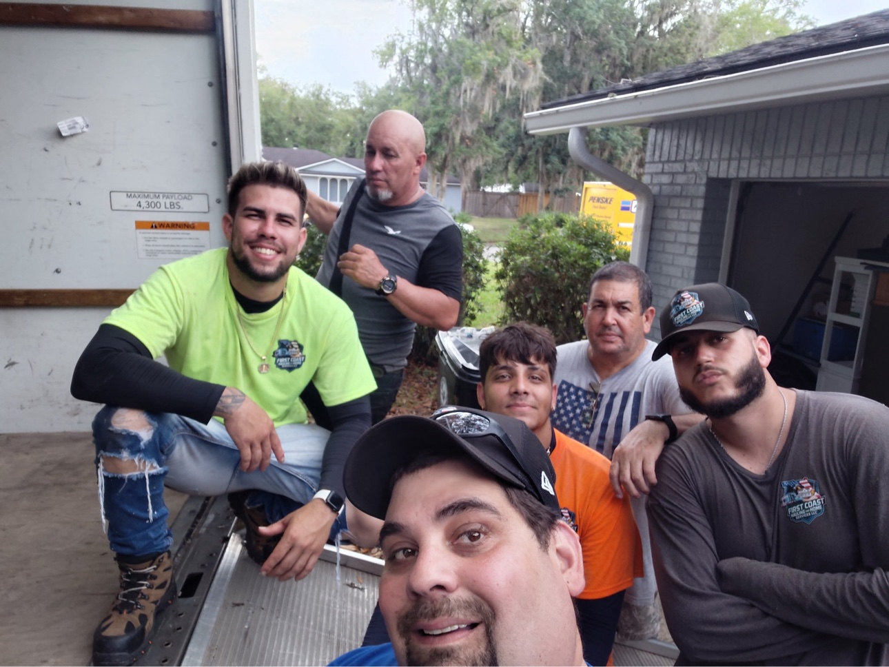 Carlos Capote, owner of First Coast Hauling and Home Services standing in front of his service vehicle