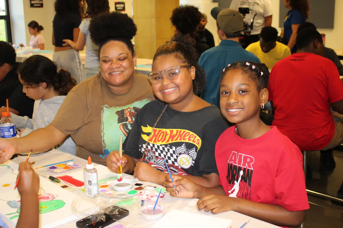 Volunteer tying shoelaces for a child.