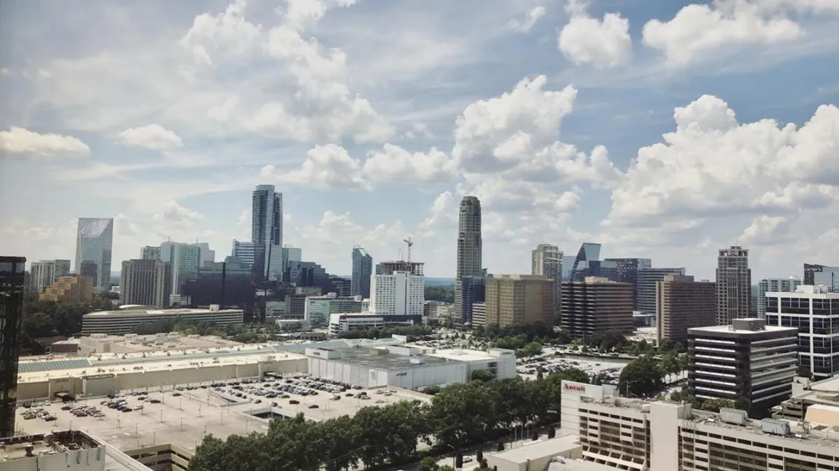 Modern city skyline with tall skyscrapers, office buildings, and cloudy blue sky — urban landscape view