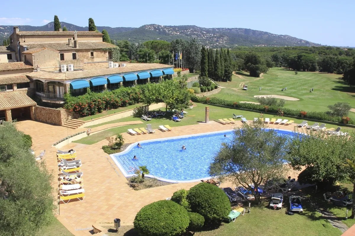 Outdoor pool surrounded by palm trees, with a dedicated area for team activities and a nearby modern gym. The setting is sunny, energetic, and perfect for post-game relaxation or training.