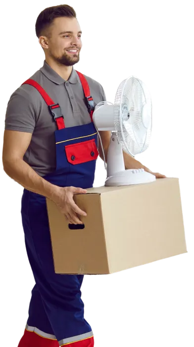 Pracovník společnosti STĚHUJEME PRAHU nese krabici a ventilátor během stěhování.