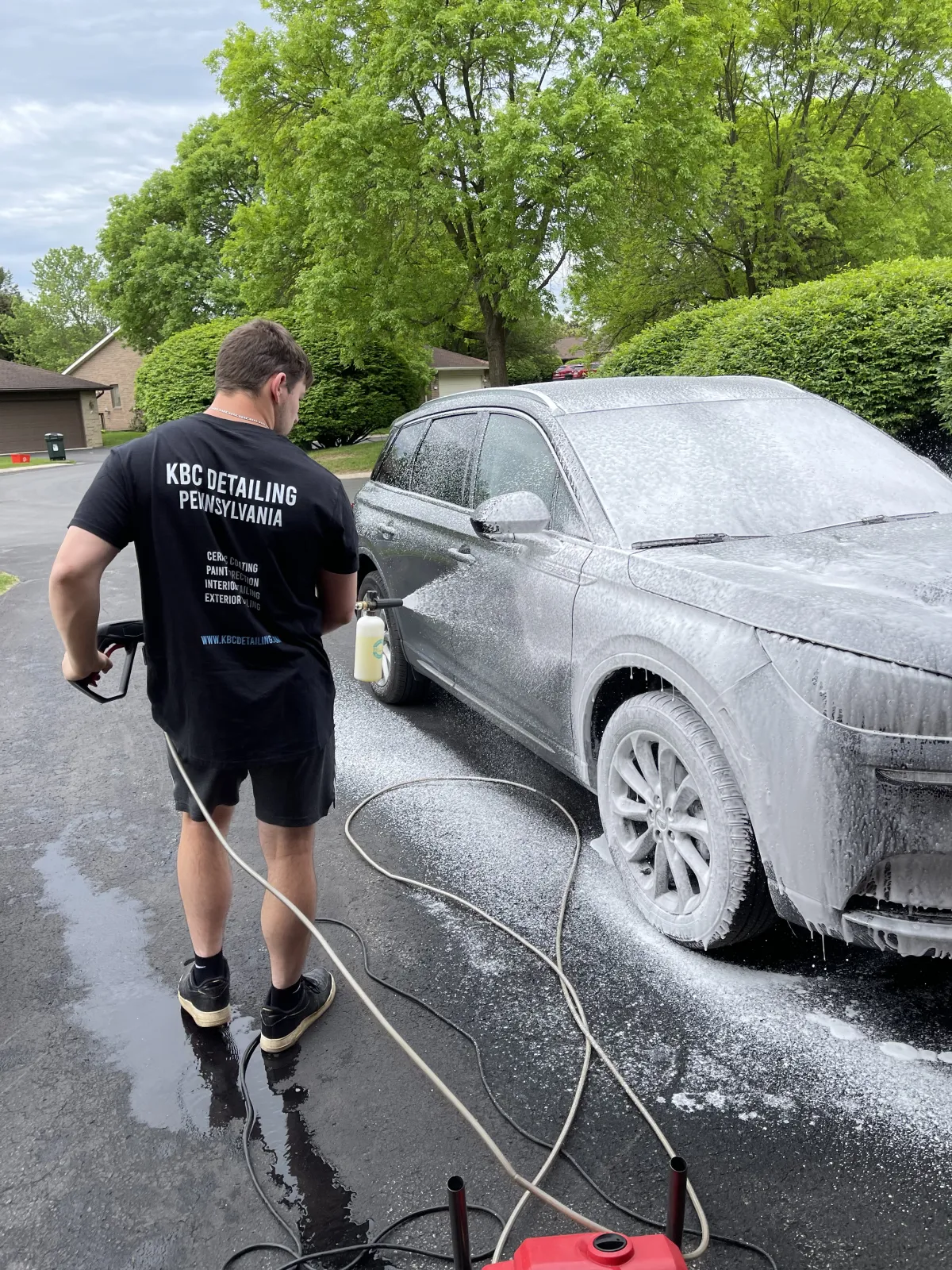 Using Proper Wash Techniques to hand wash a Gray SUV