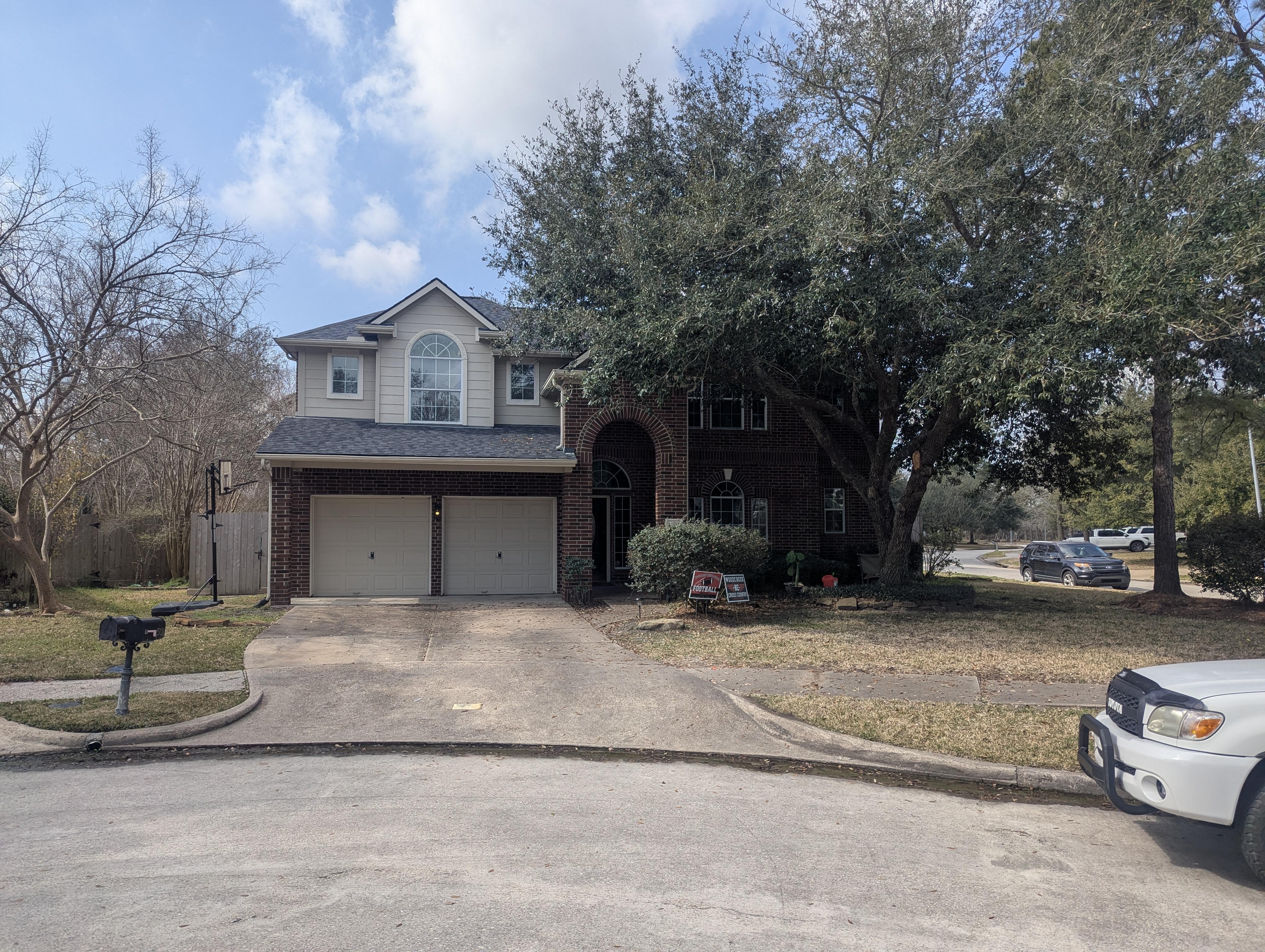 Two-story home and driveway before pressure washing in Houston TX showing dirt, algae, and buildup on concrete and exterior surfaces