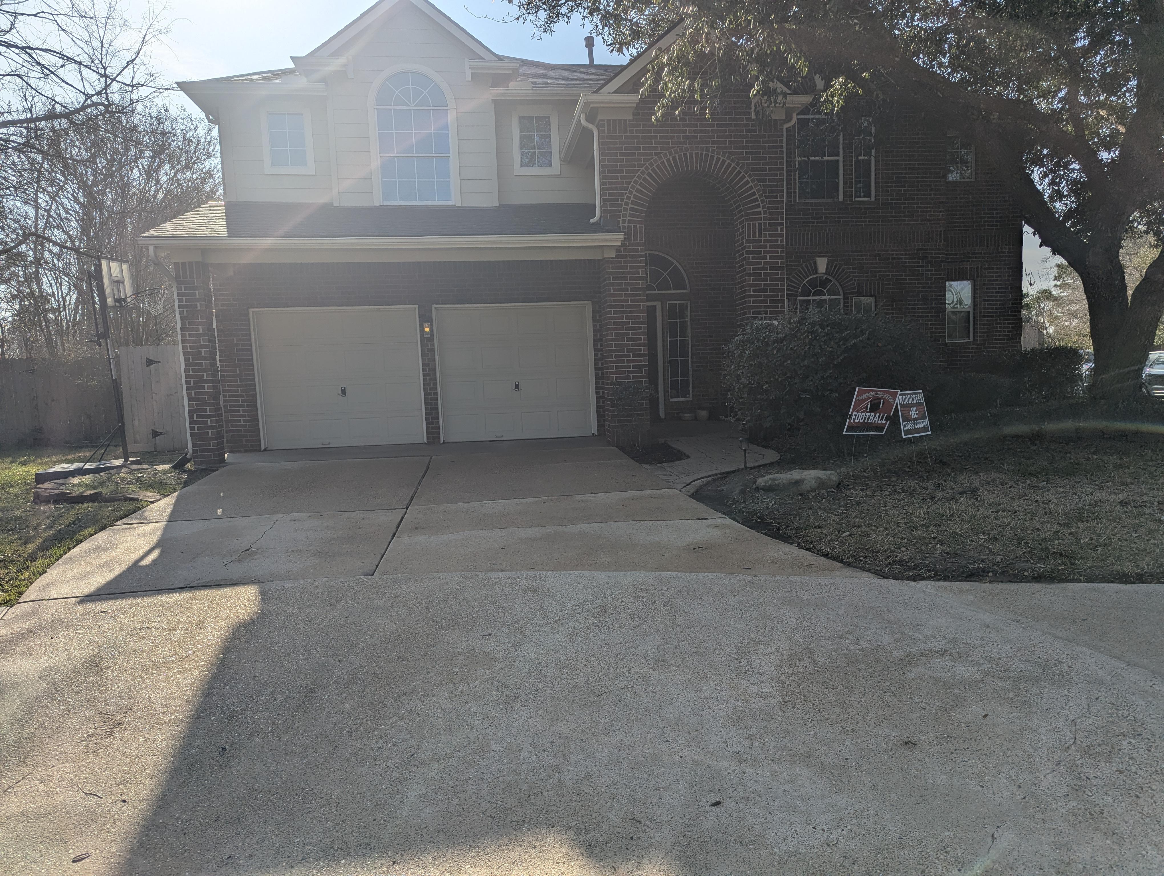 Two story home driveway and garage after pressure washing in Houston TX with clean concrete and refreshed exterior surfaces