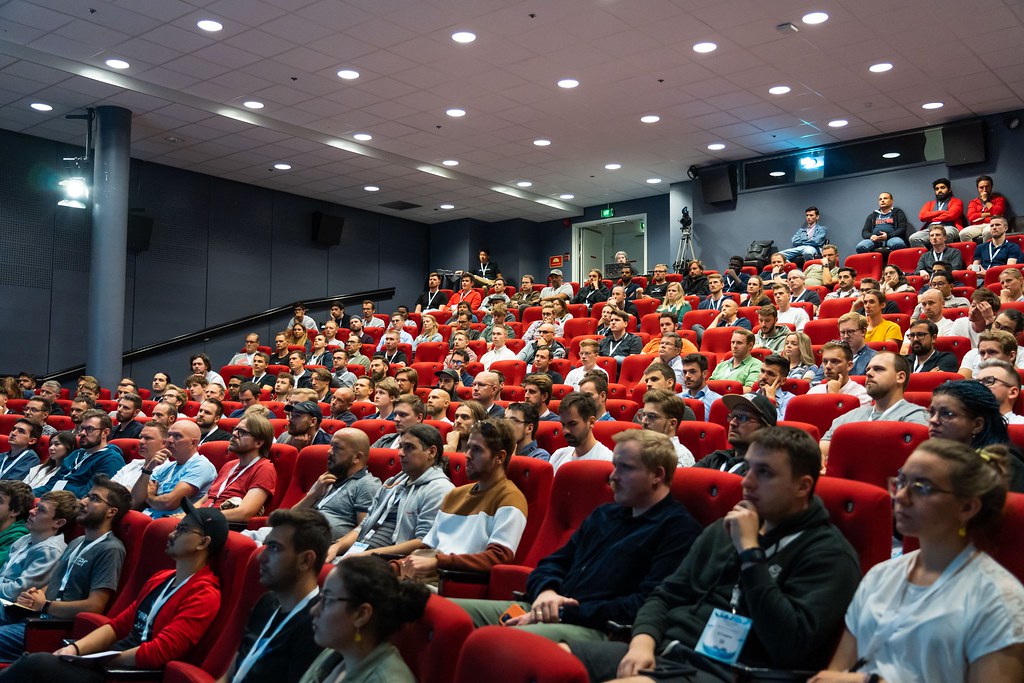 Large audience of tech conference attendees filling an auditorium in Oslo
