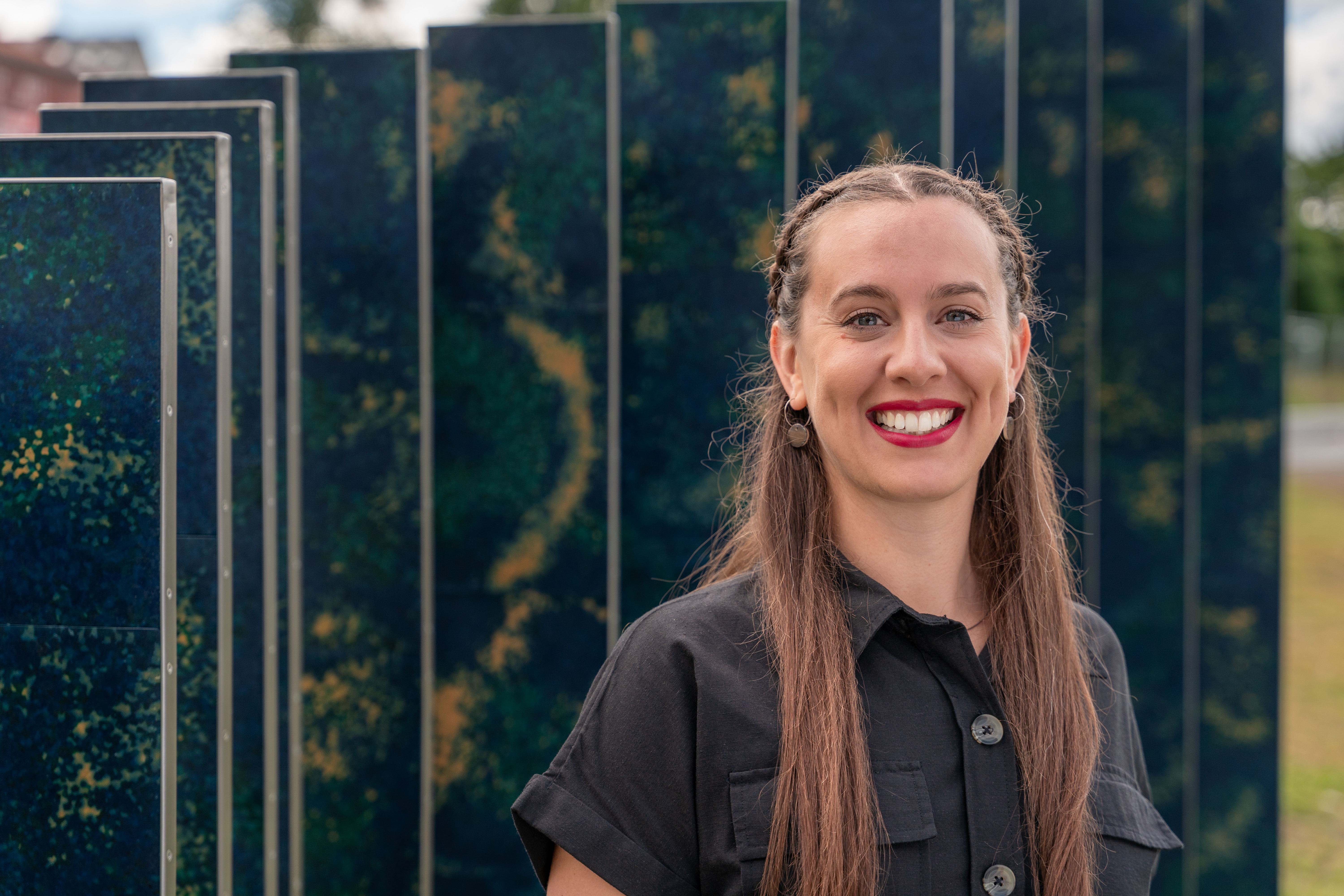 Aphra Shemza standing in front of the art instillation