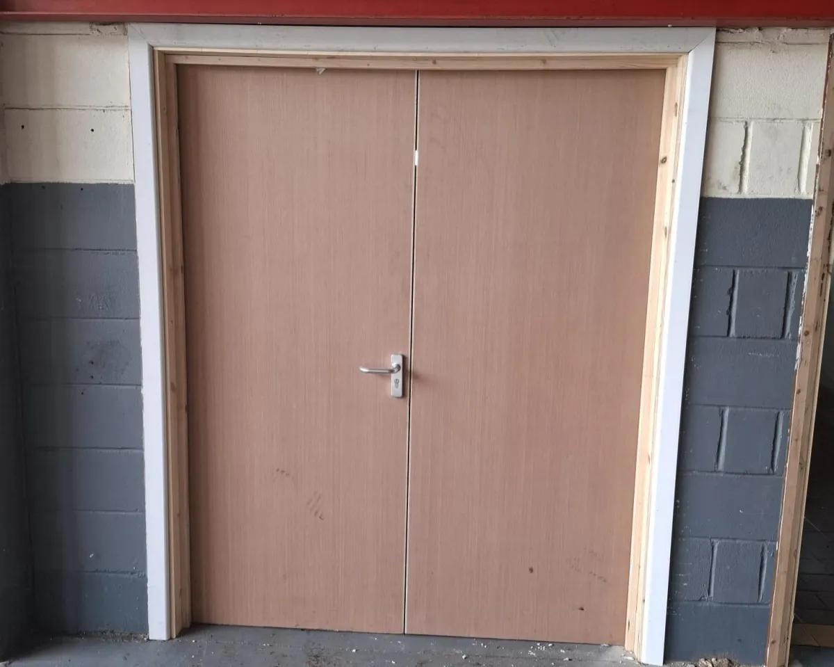 Construction company in Bilston checking a fire door frame