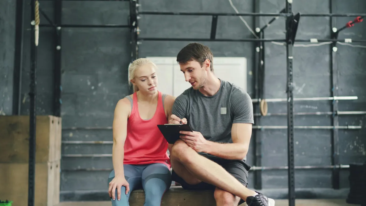 Personal trainer coaching a client through her program