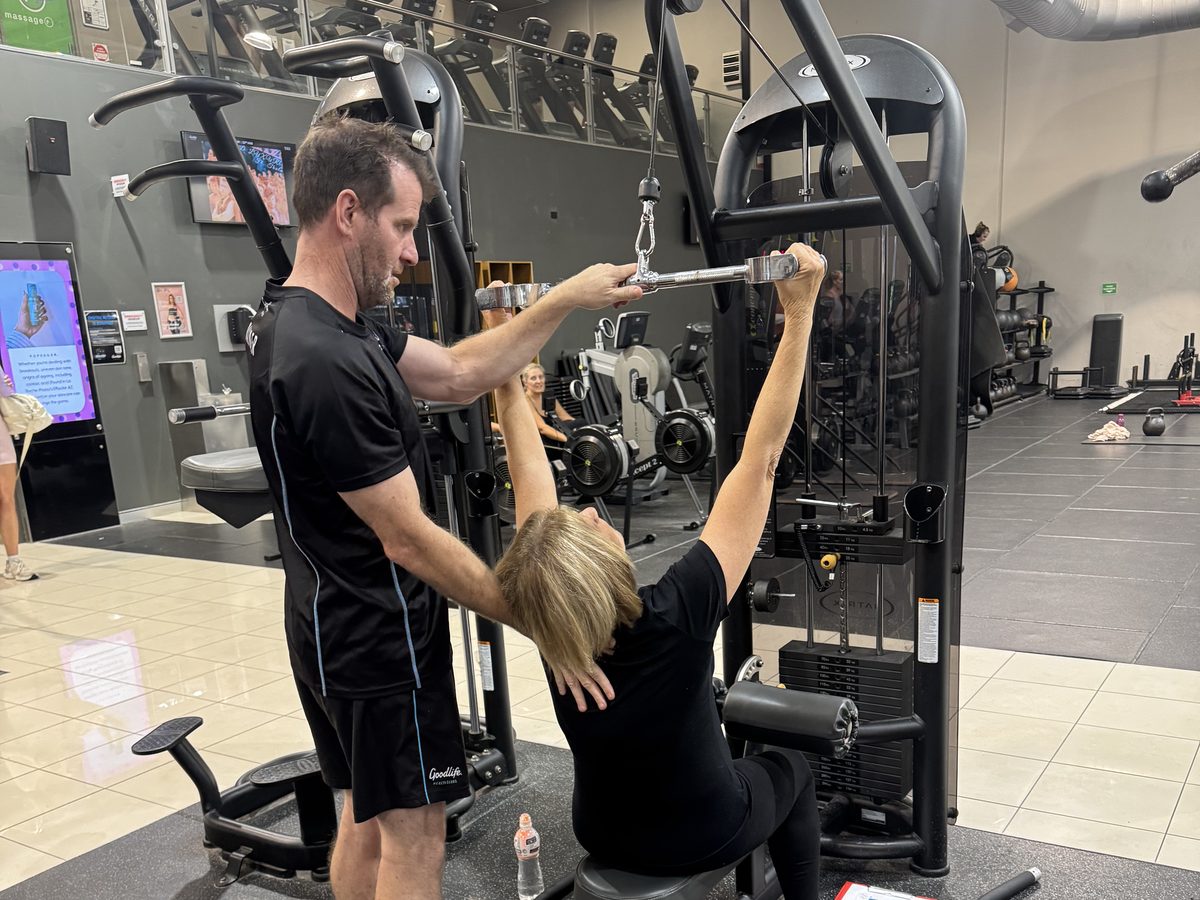 Ian Pedler coaching a client through a lat pulldown at Goodlife Burleigh Waters