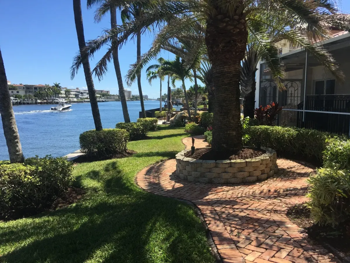 Landscaping with palm trees and brick paver walkway in Deerfield Beach – Quality Lawncare
