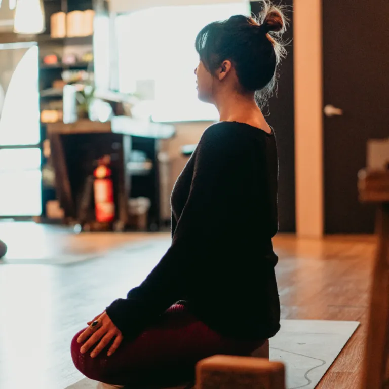 Person seated calmly with relaxed shoulders doing a gentle neck stretch