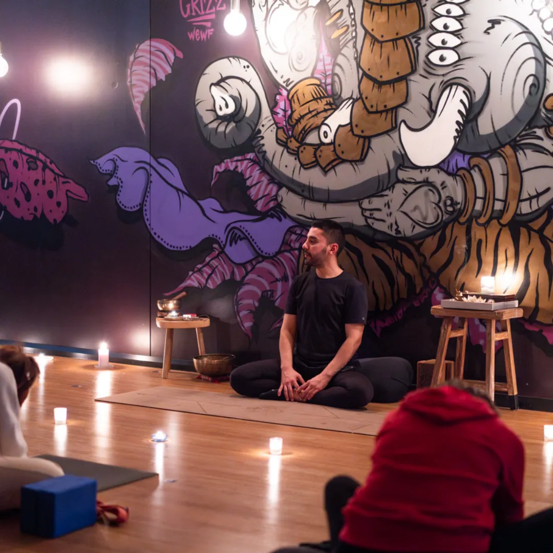 Person in a calm evening setting practicing gentle breathing on a yoga mat