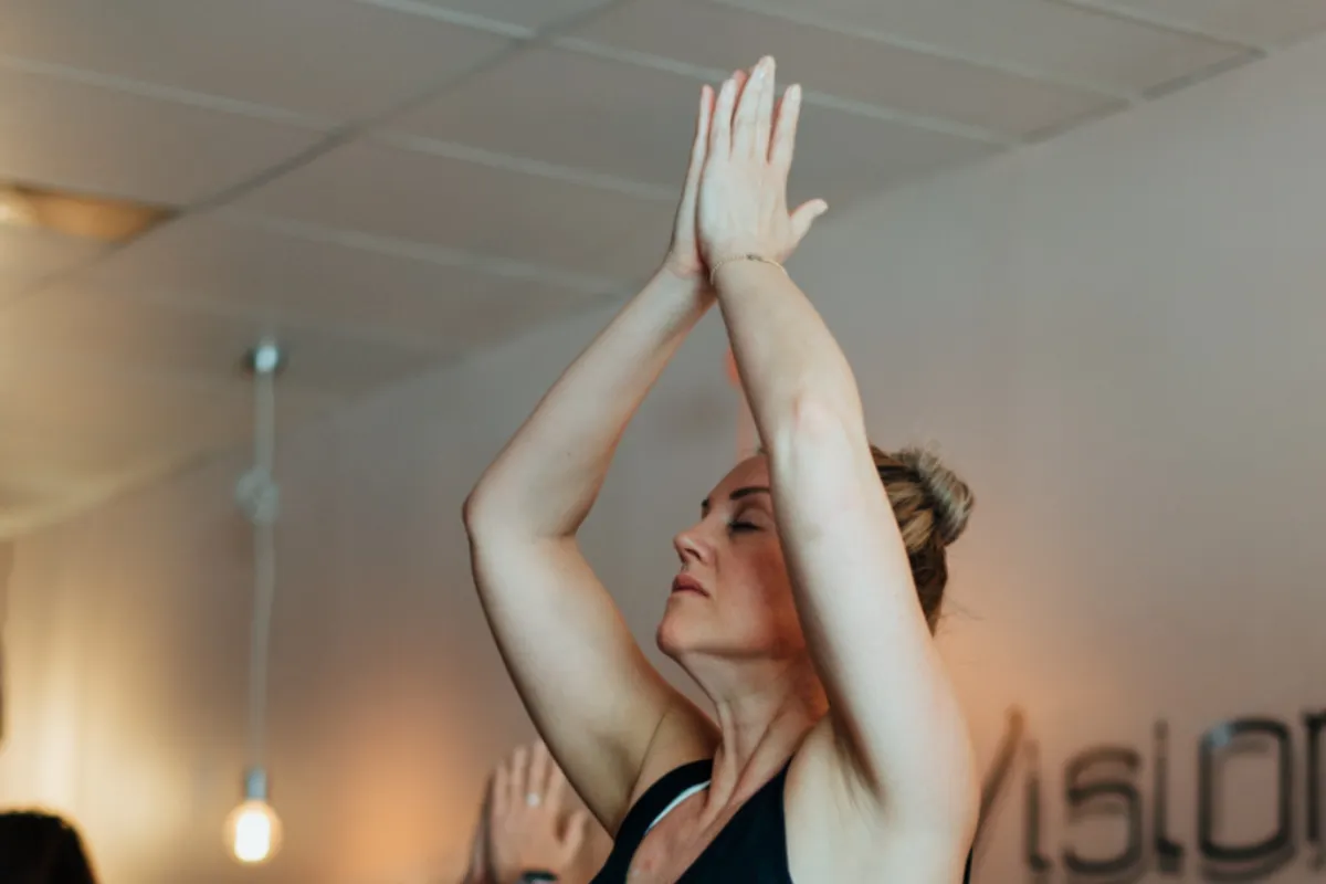 A woman practicing breathwork, sitting calmly with eyes closed, focusing on her breathing for stress relief and mental clarity.