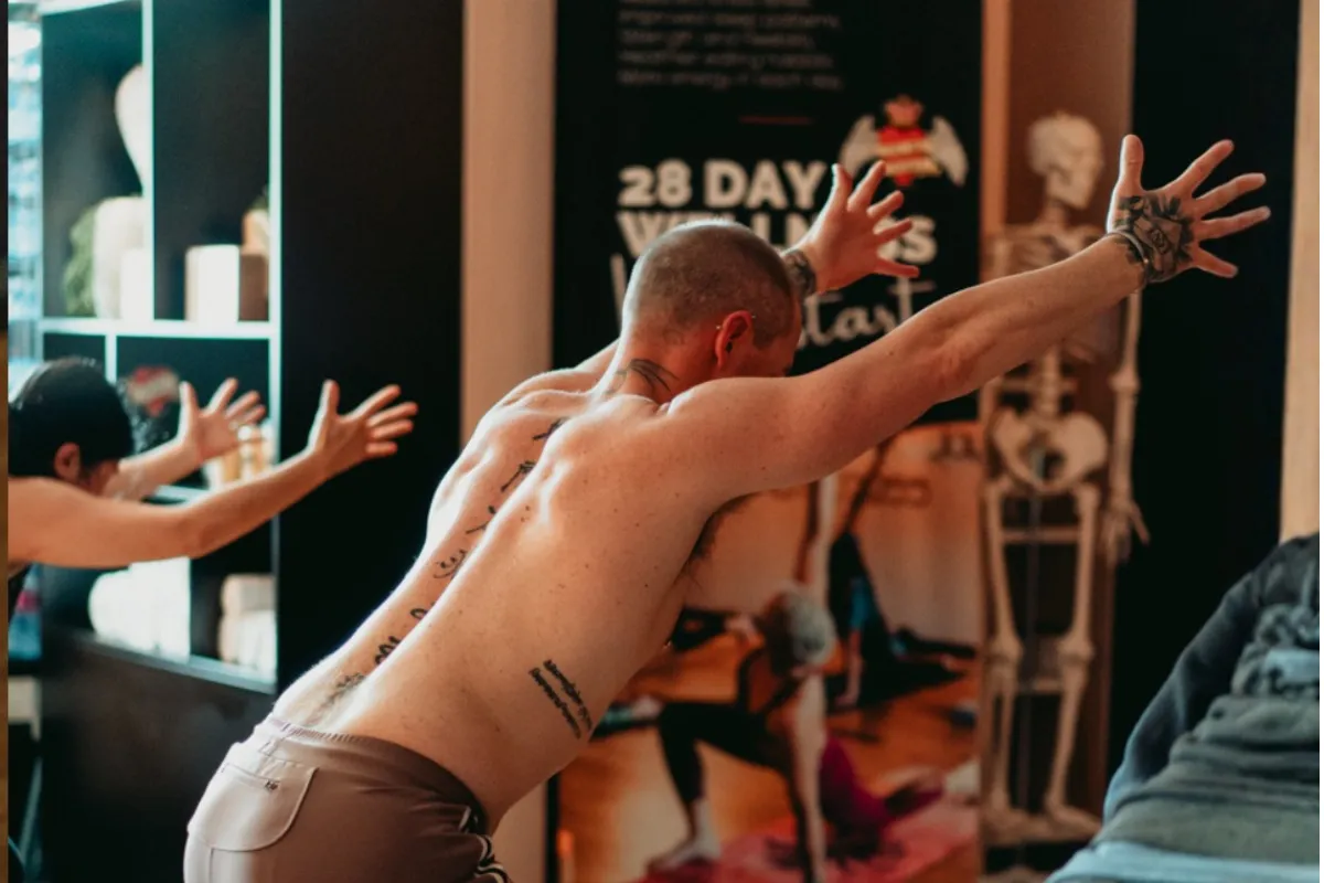 Person practising Chair Pose yoga with arms overhead and knees bent, demonstrating correct alignment for leg and core strength