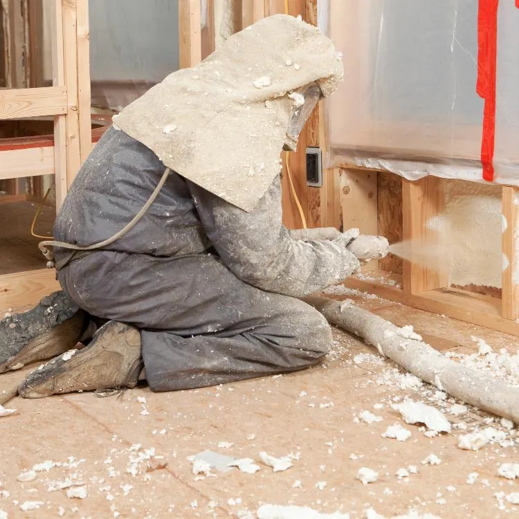 Worker applying spray foam insulation