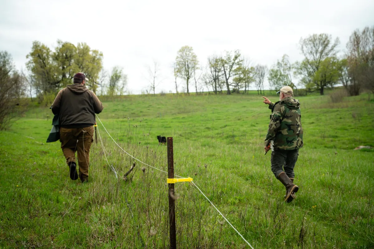 Participants at Acres U.S.A. water management intensive walking through pastureland during hands-on field training on Master Line system layout and excavation