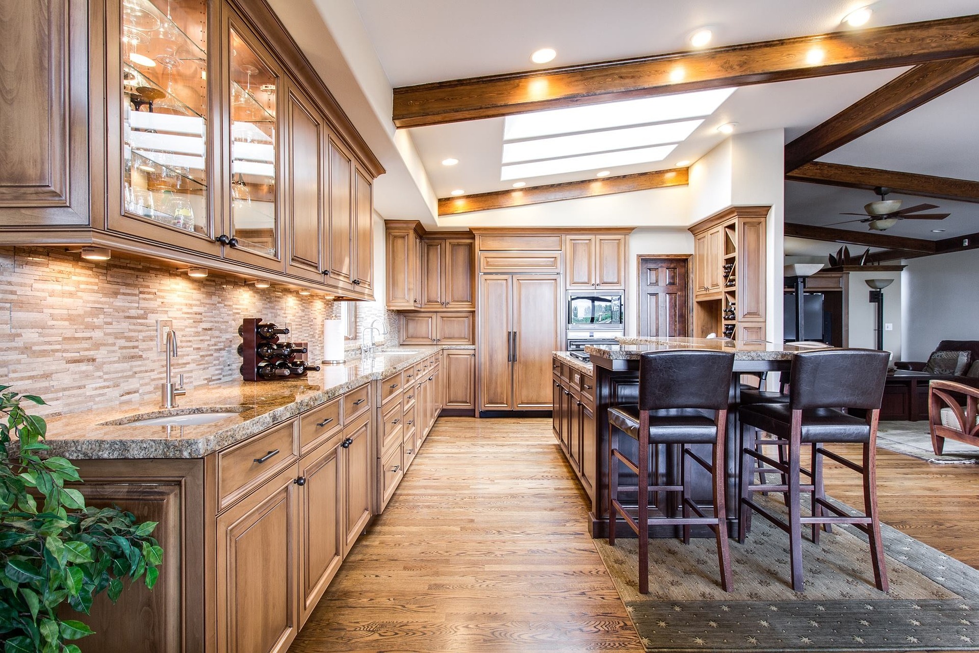 Luxury kitchen with wood cabinetry, hardwood flooring, and exposed ceiling beams