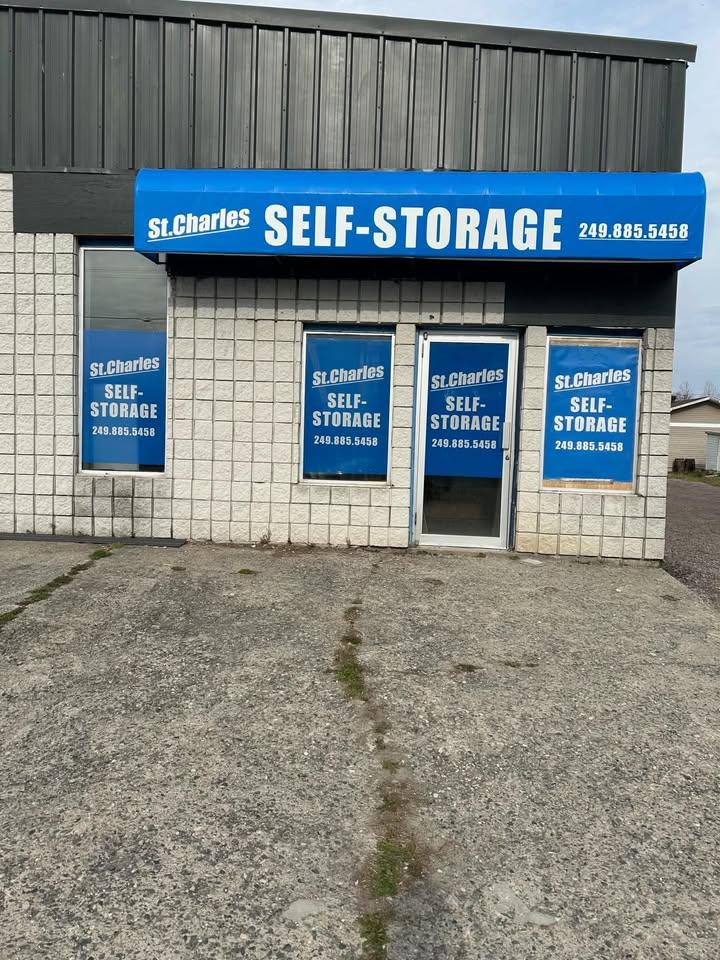 Brightly illuminated modern self storage corridor with polished concrete floors and secured orange and steel roller units
