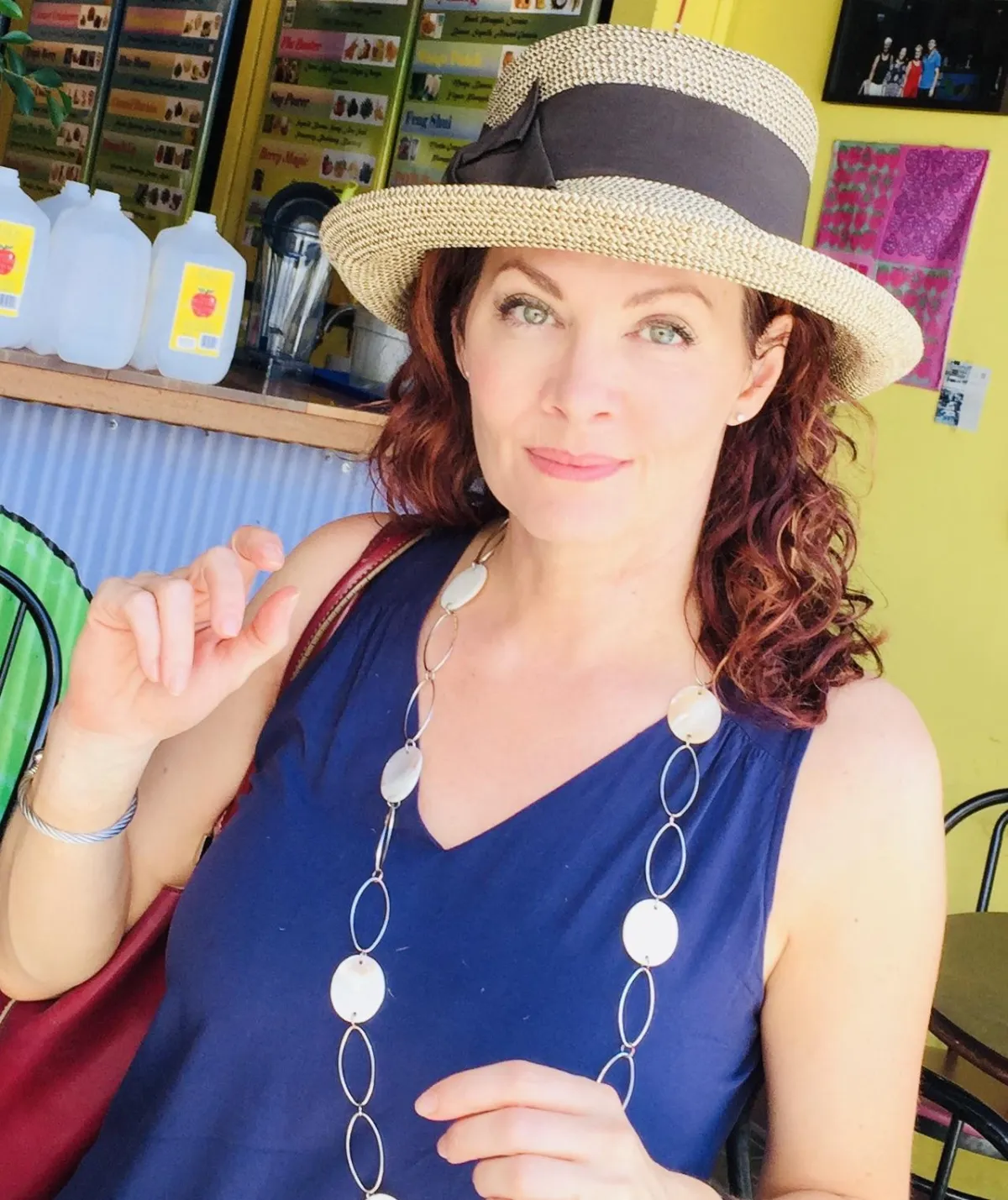 Middle aged woman in blue sundress and straw hat at a market 