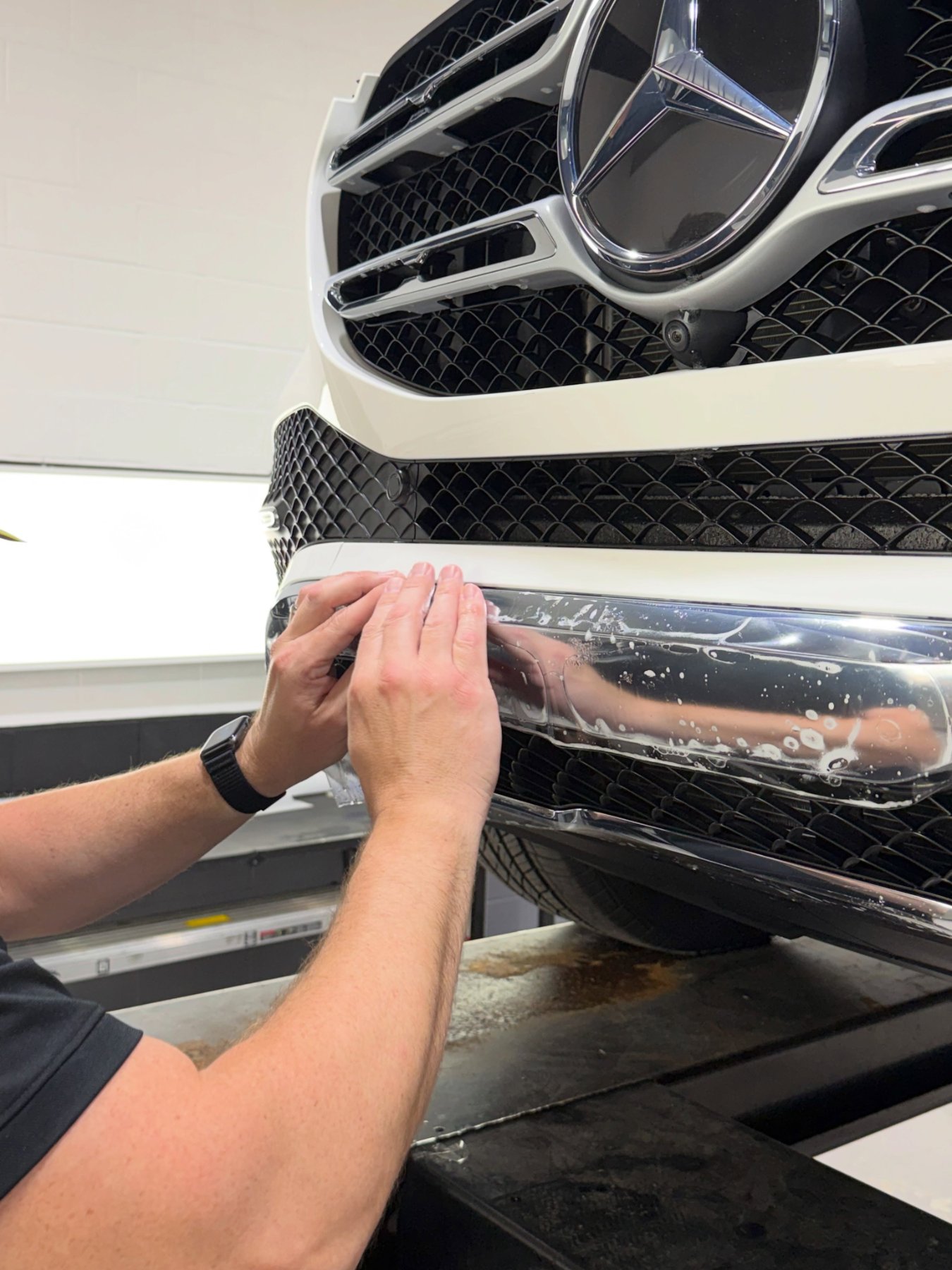 PWP Detailing technician installing paint protection film on a front bumper