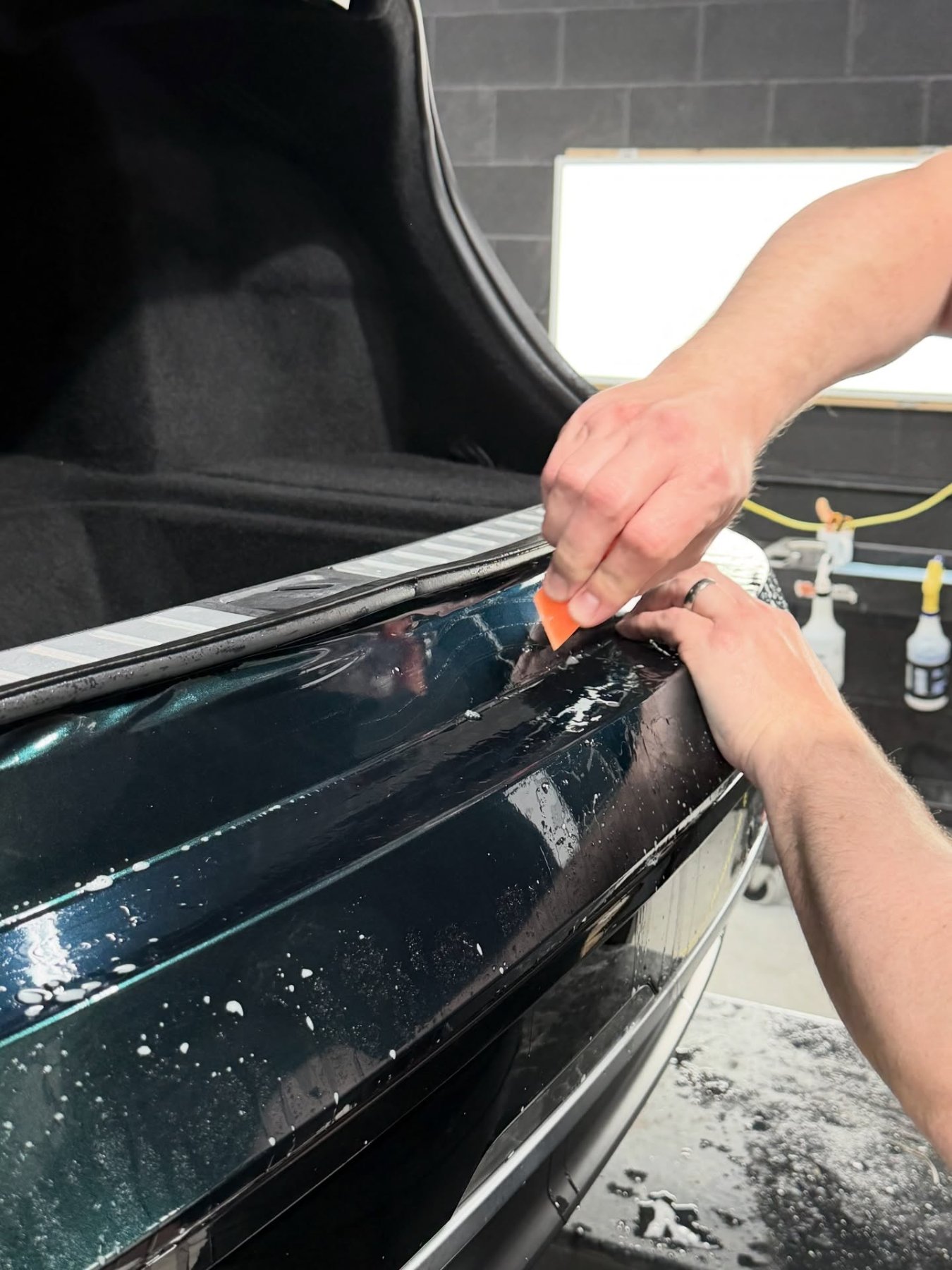 Trimming color change paint protection film on a Lucid Air at PWP Detailing