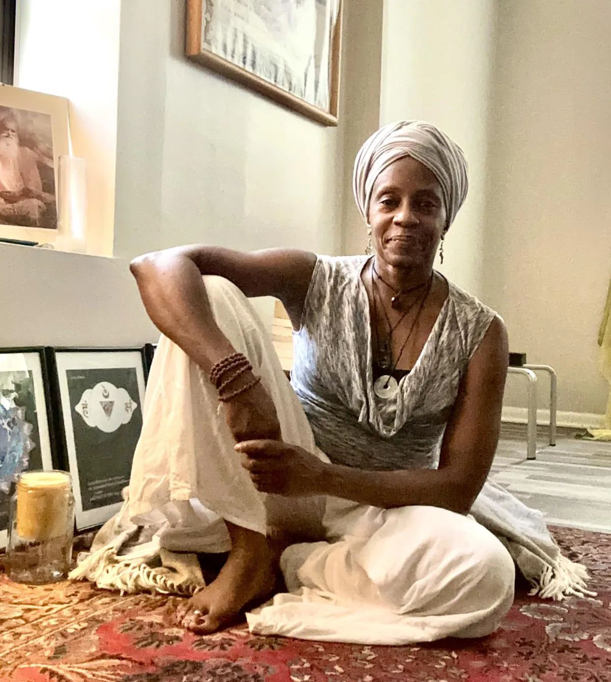 Yoga Mentor Bharati Carla, a woman sitting on a vintage rug in yoga center