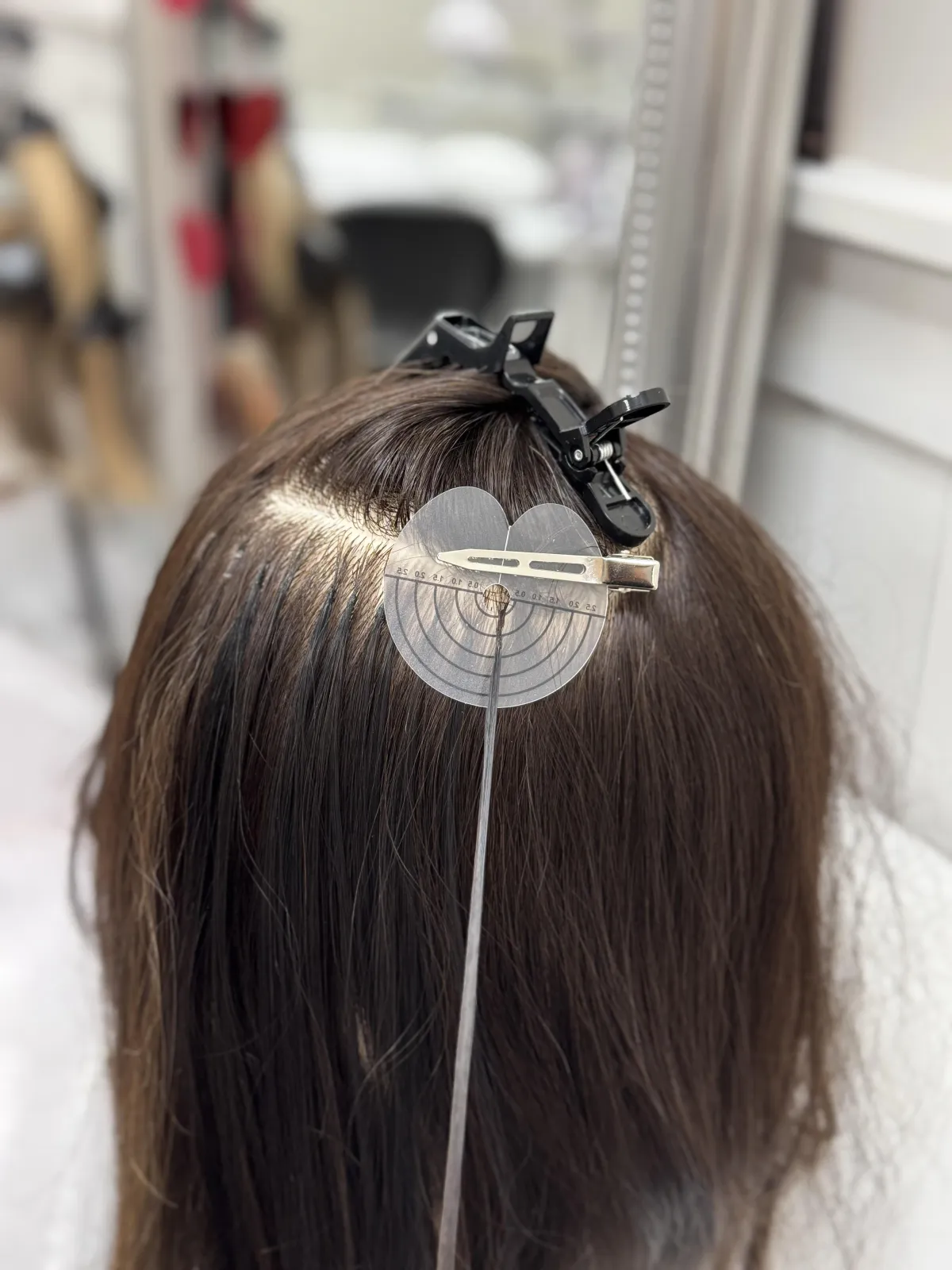 Woman in elegant black dress seated in ornate chair.