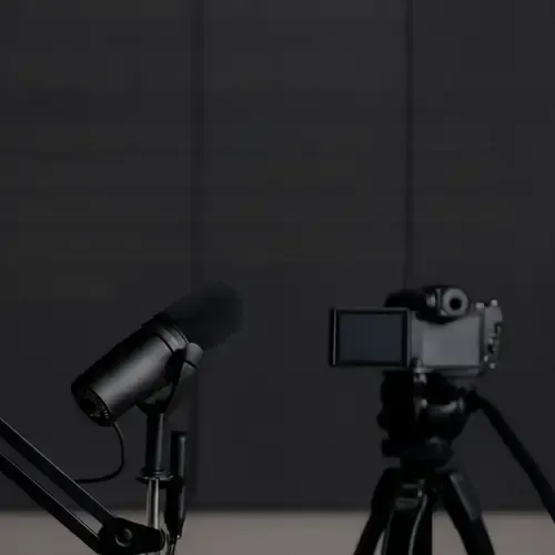 A photo of a microphone and a camera on a dark background