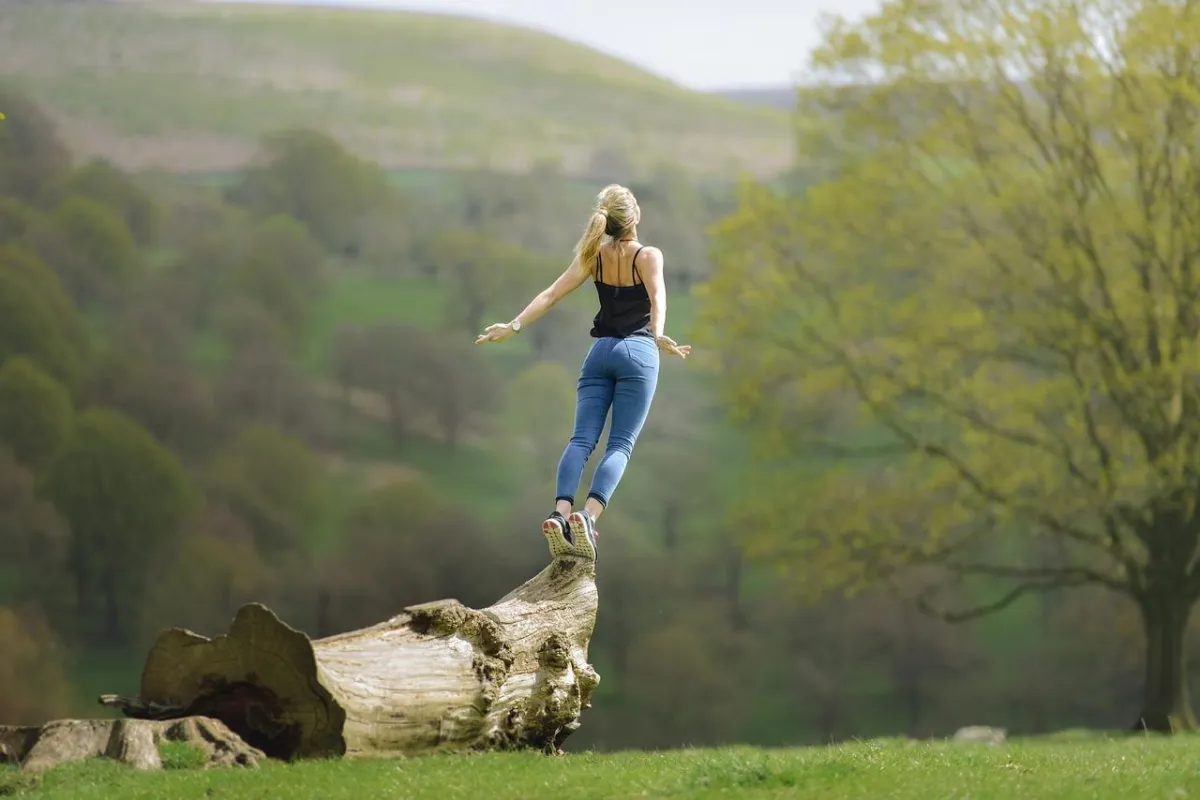 Girl happily jumping off log