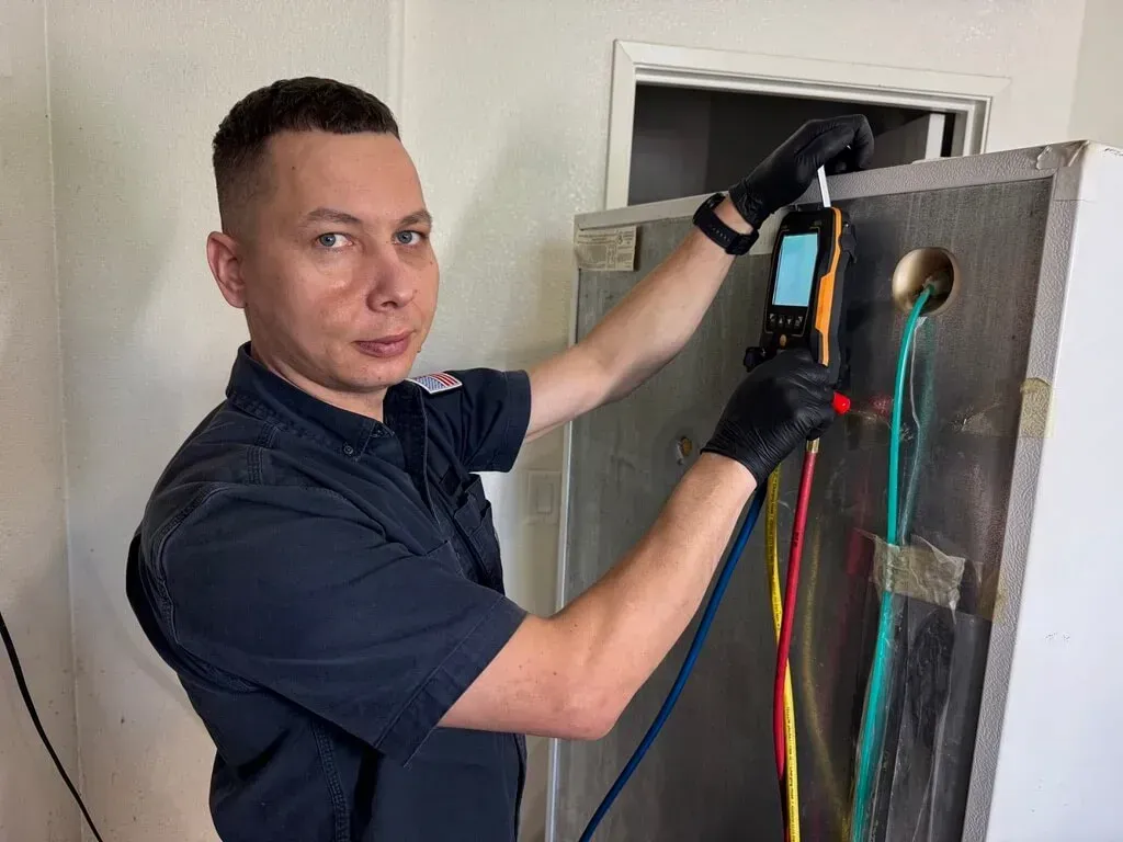 Refrigerator repair technician checking sealed system pressures in Elk Grove California.