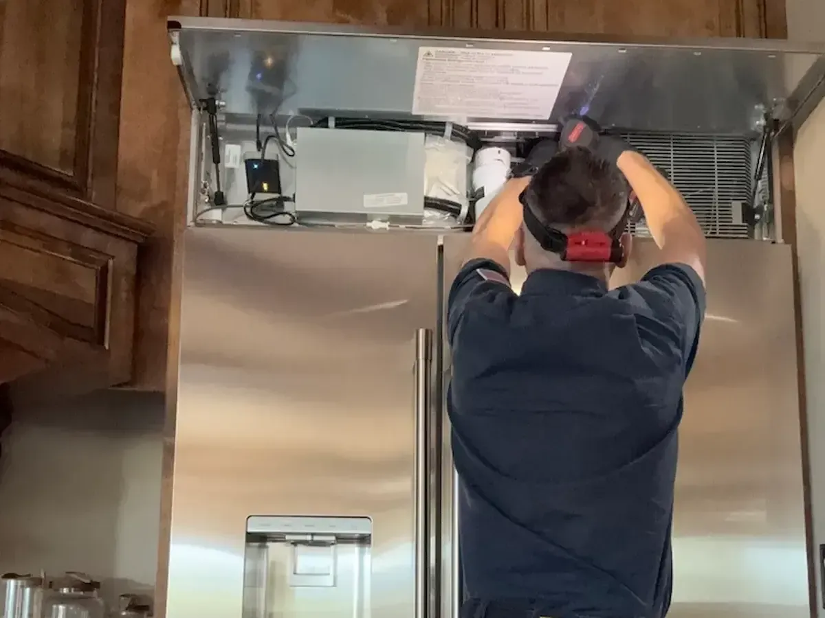 Built-in refrigerator repair technician performing cooling system diagnostics in Fairfield, CA California