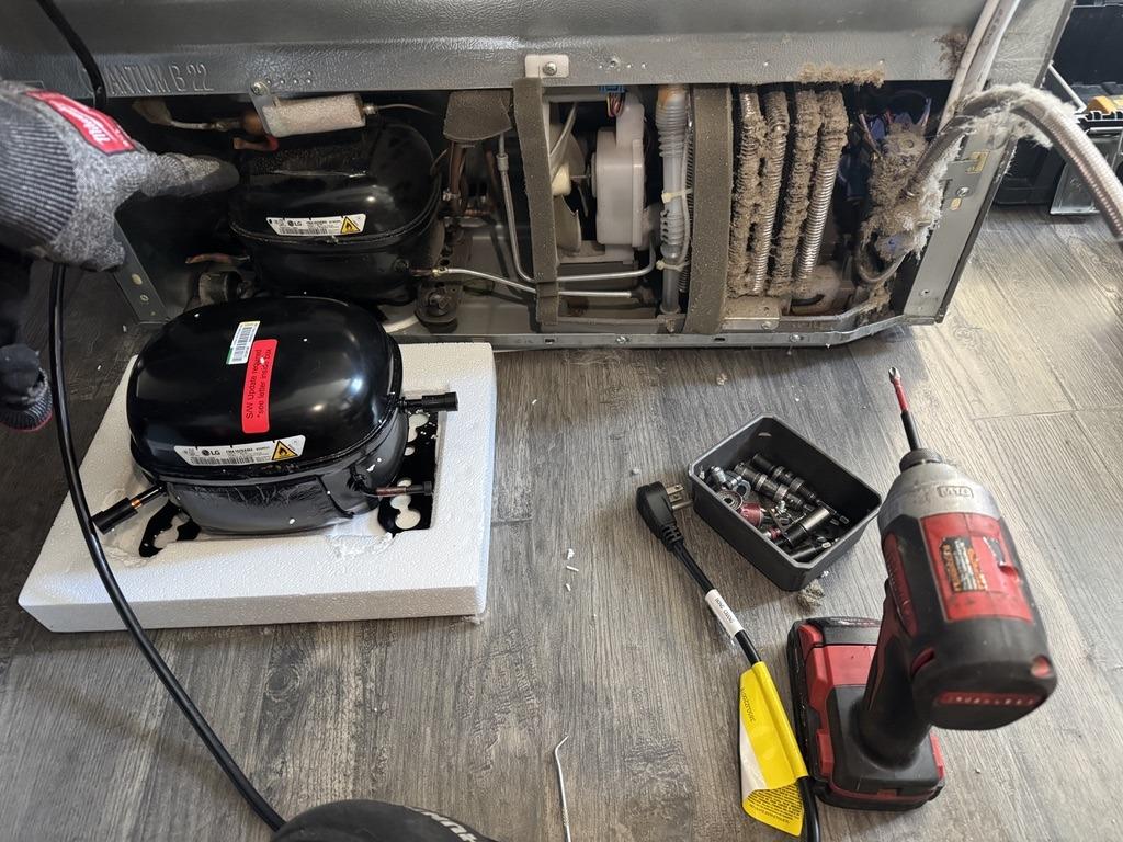 Old and replacement LG refrigerator compressors during a Sacramento-area no-cooling repair