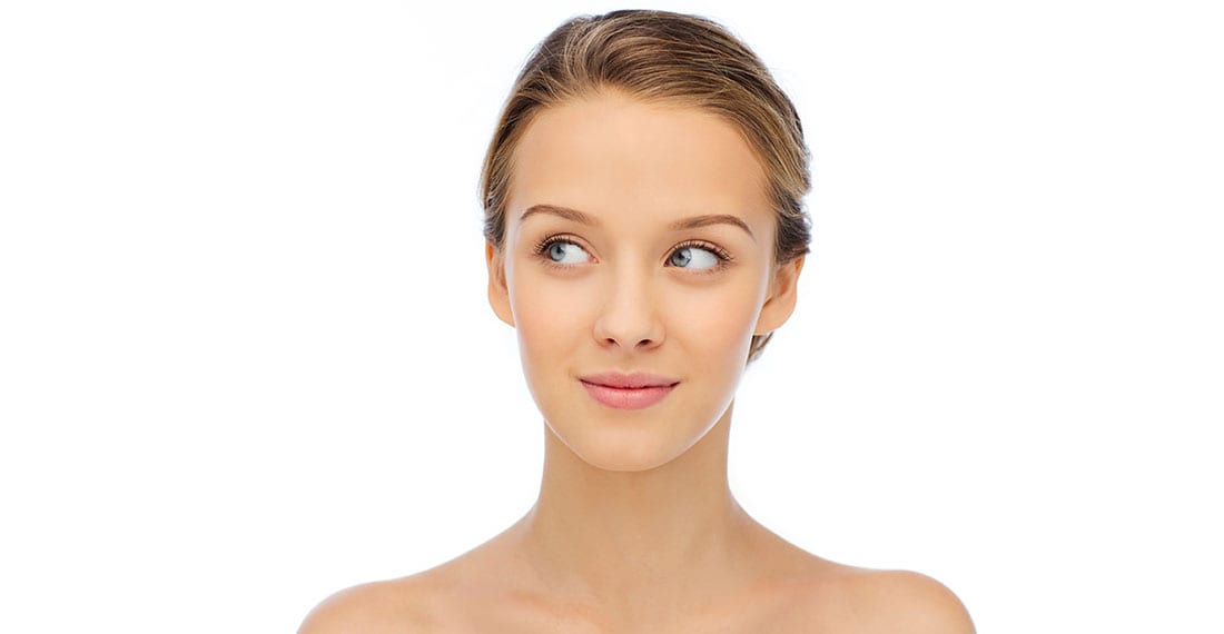 person holding clear glass bottle