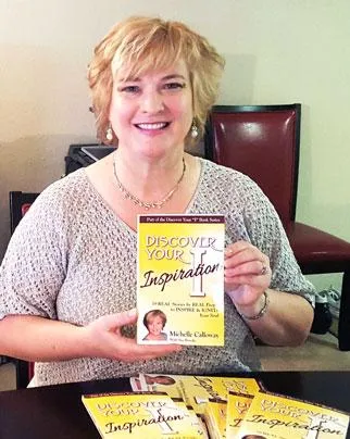 Michelle Calloway holding her book, Discover Your Inspiration
