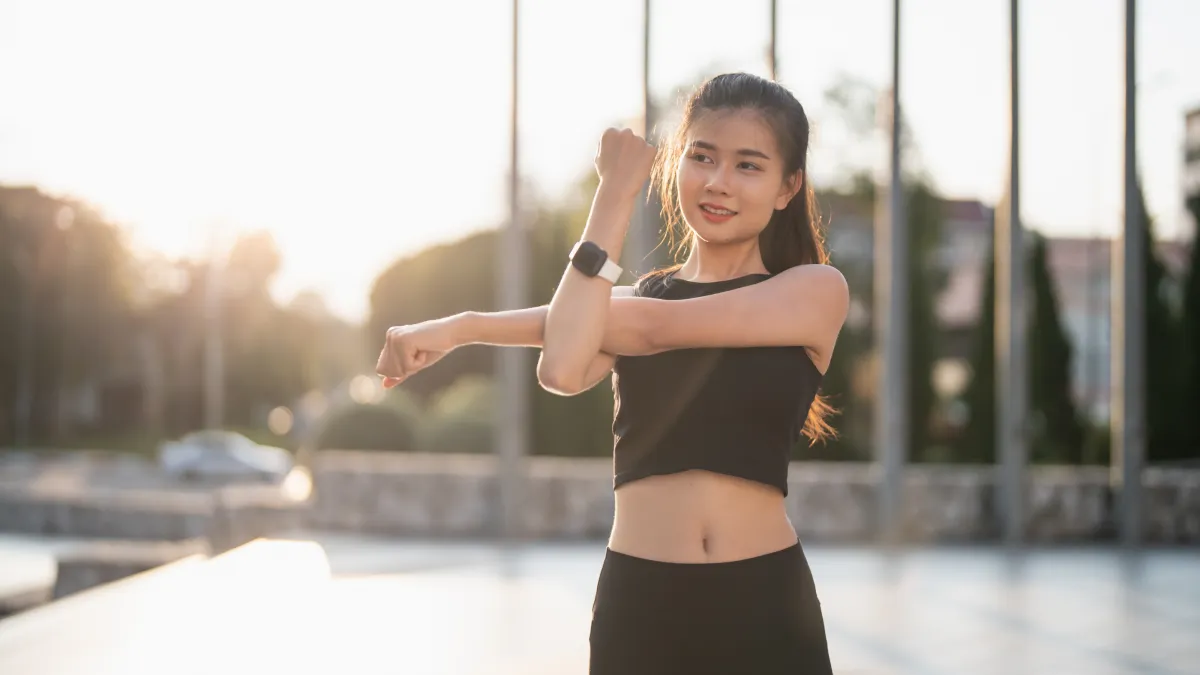Woman stretching outdoors as part of a healthy morning routine