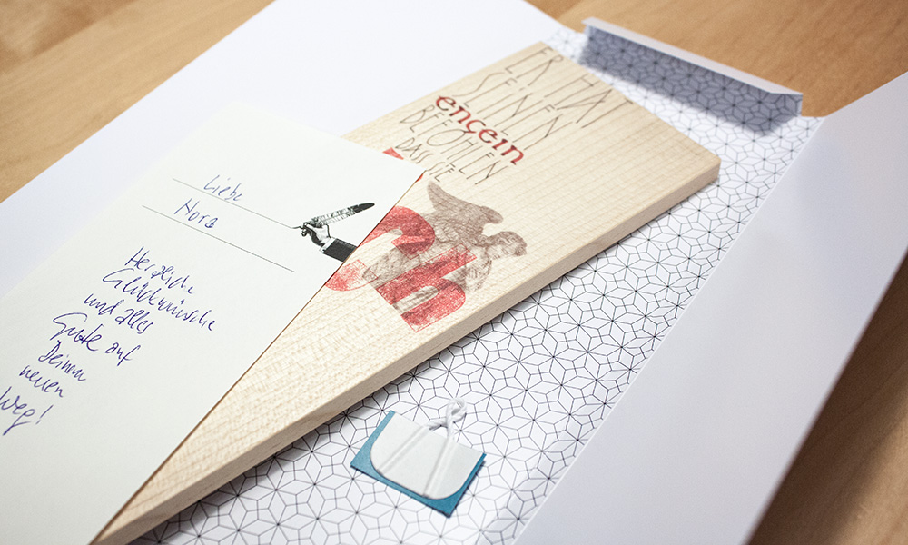 Täfelchen in einer Geschenkhülle mit einem Grußzettel
