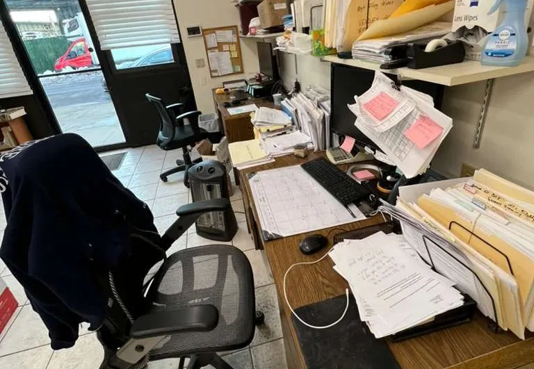Hand holding a white and black spray bottle.
