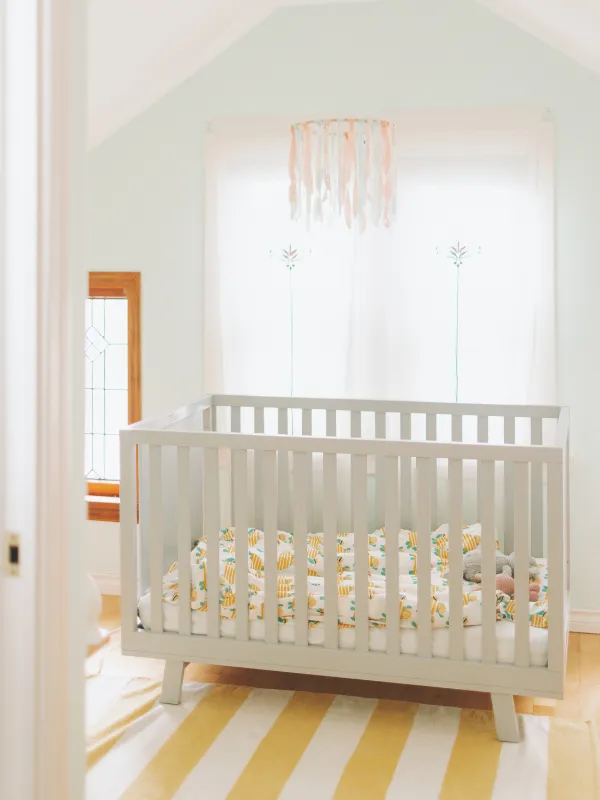 A modern nursery with a crib front and center.