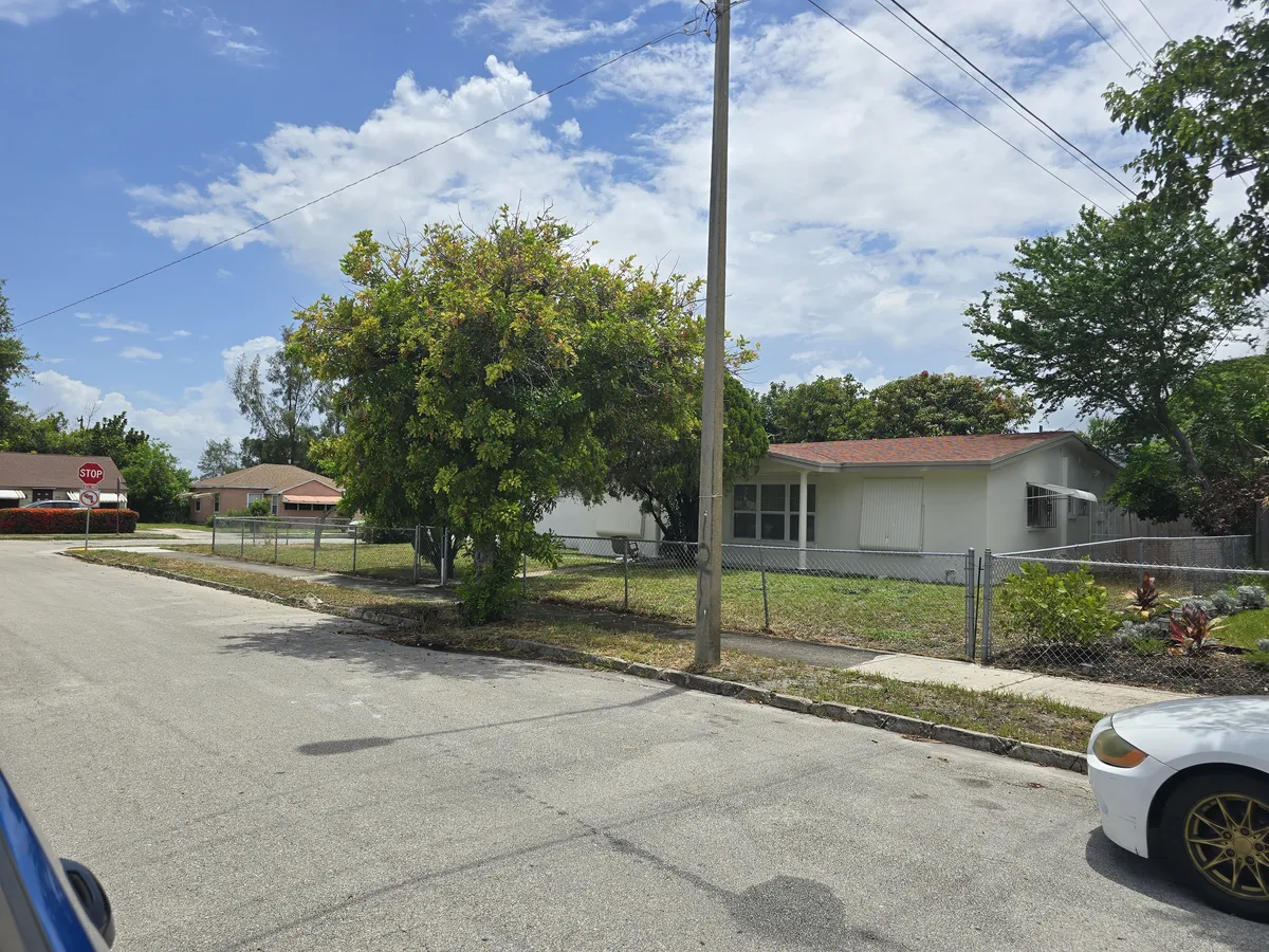 Street view of the Conquer Mental Health recovery home and fenced yard in West Palm Beach, FL
