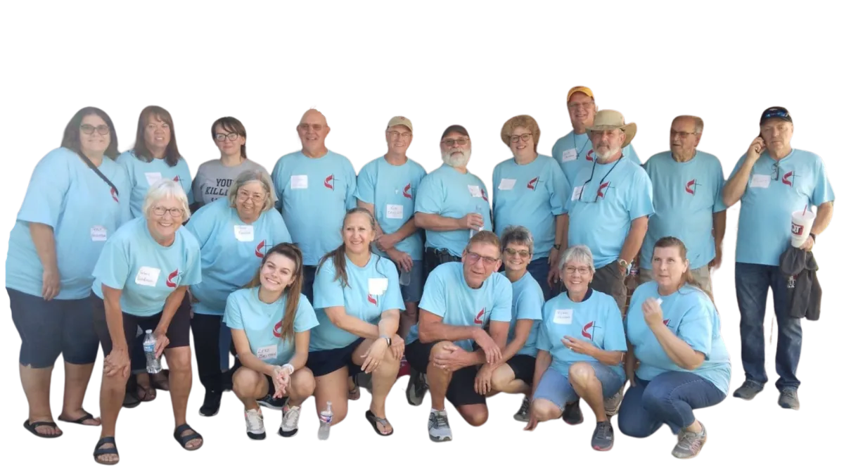 large group of smiling people in t-shirts with the UMC logo