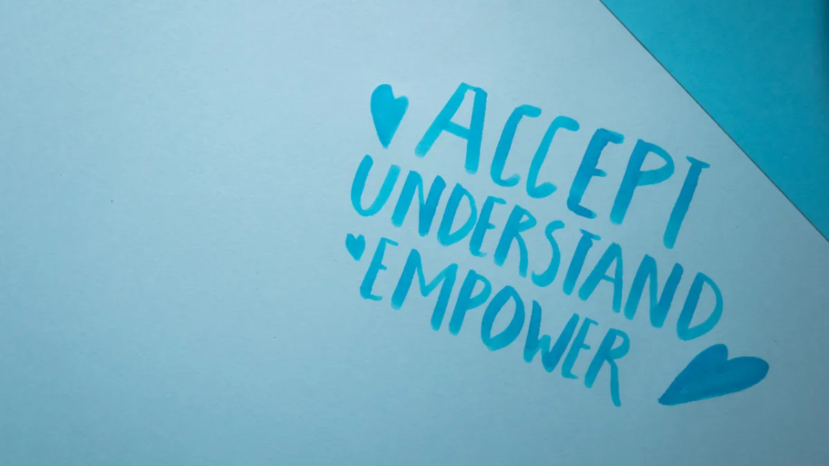 Blue paper card with the handwritten words 'Accept, Understand, Empower' alongside heart symbols, promoting inclusion and empathy.