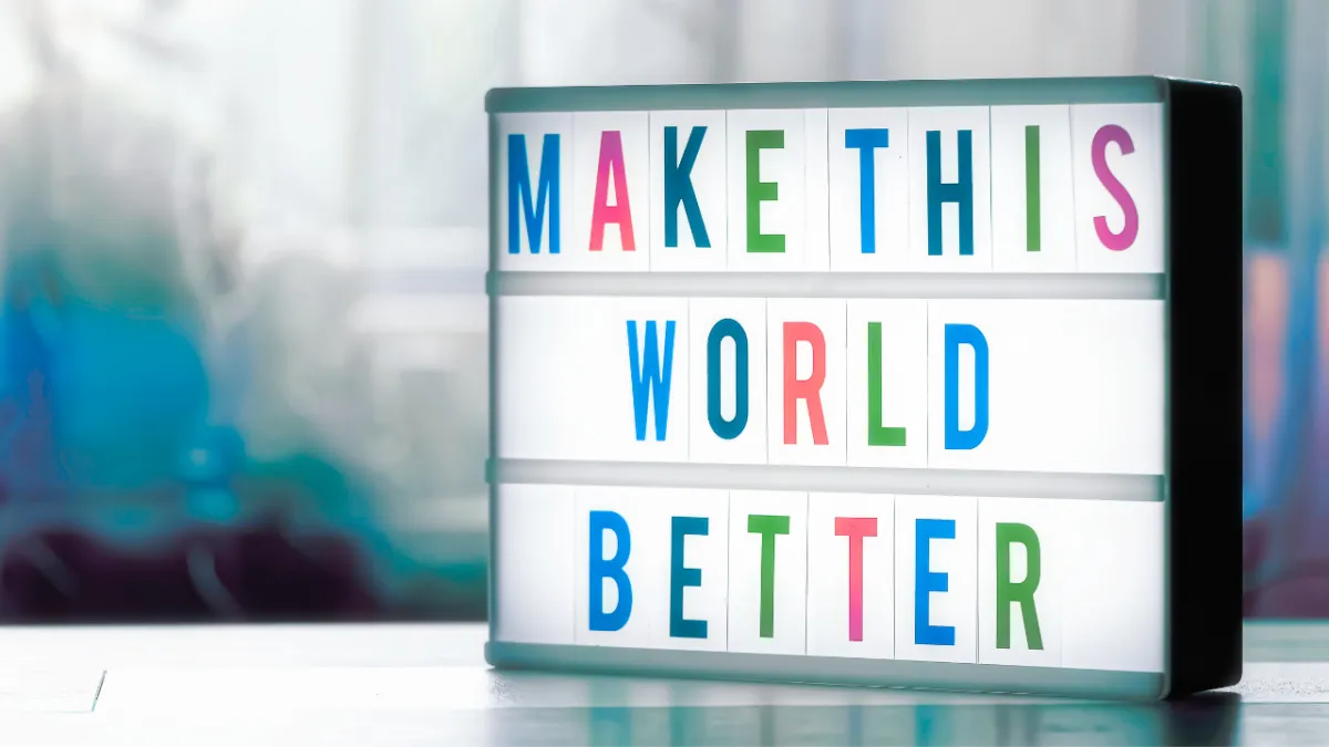 Inspirational lightbox message reading 'Make This World Better' with colourful letters, promoting kindness and positive action.