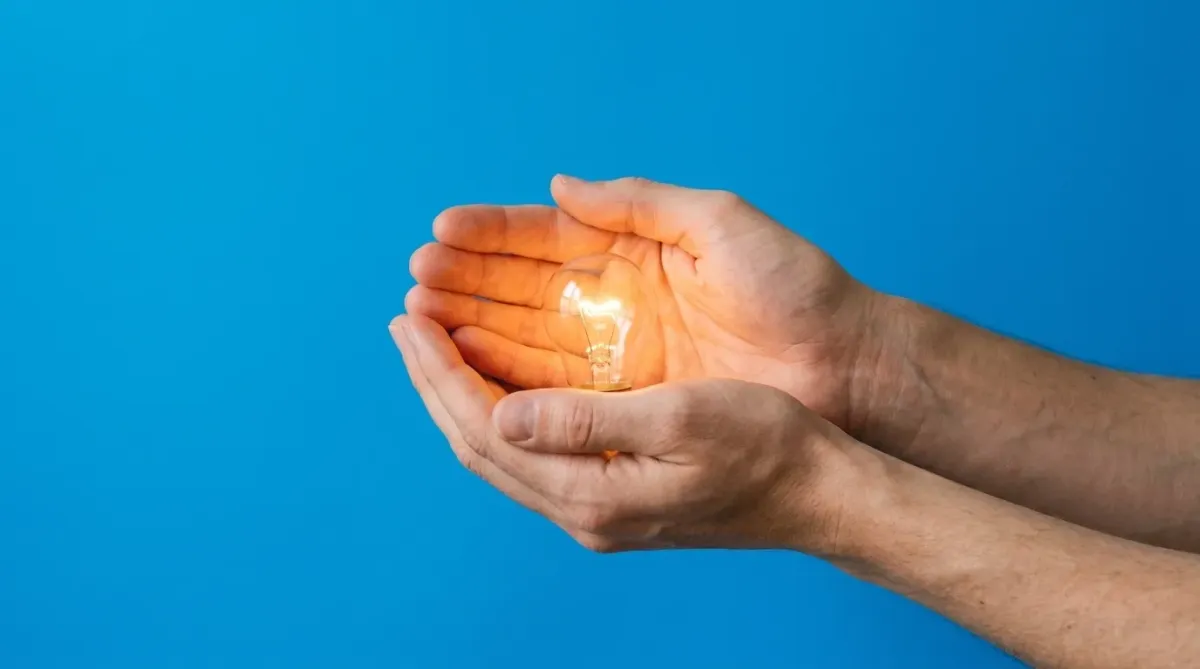 A glowing, bright spark or small flame against a dark, minimalist background symbolizing inspiration and resilience.