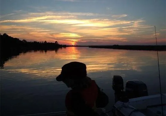 Family on a boat watching a beautiful sunset over Folly Beach, SC