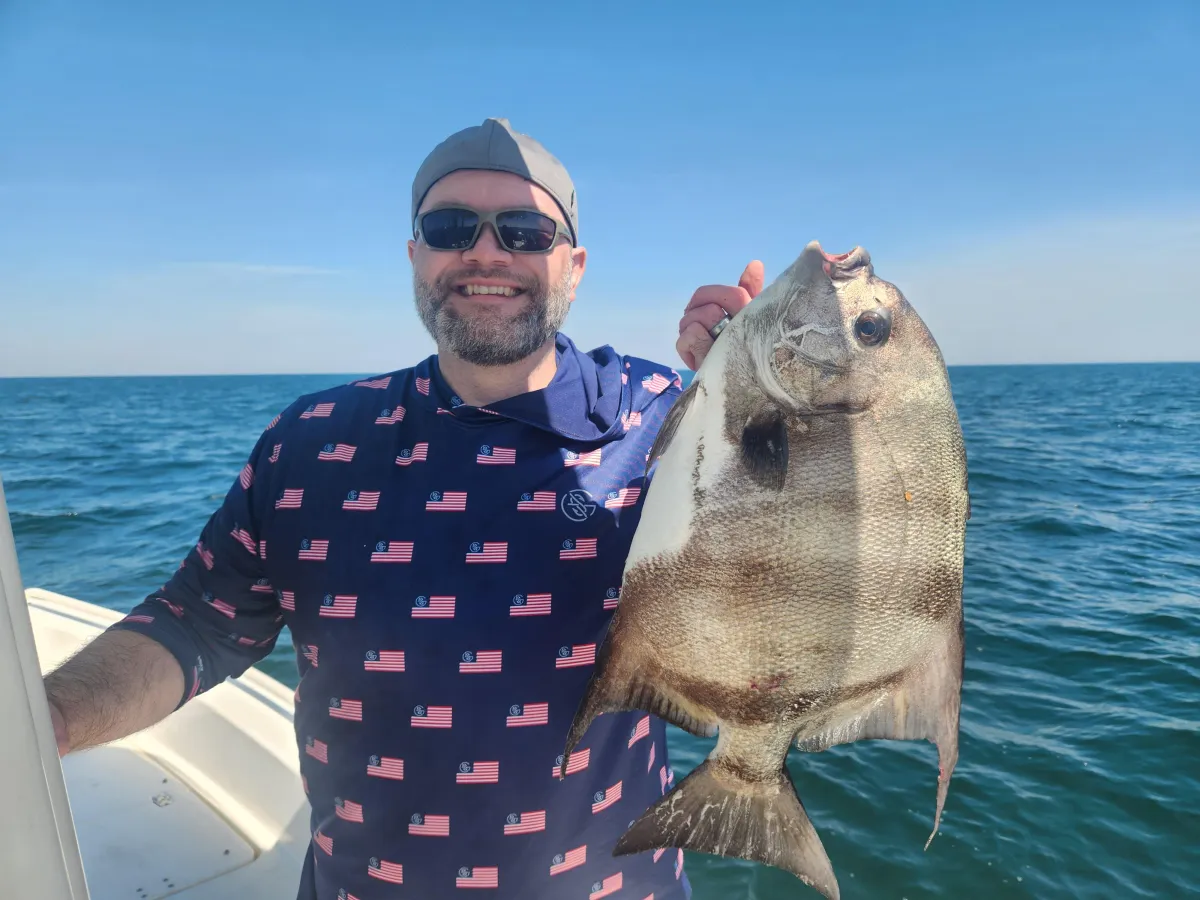 Tourist showing off the spadefish that he caught on the trip