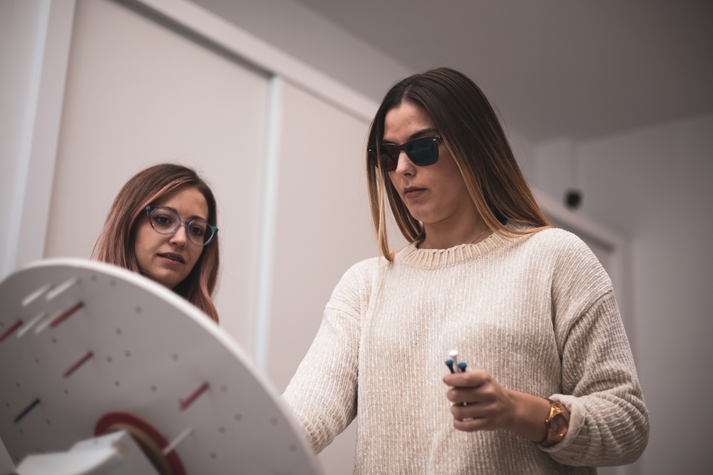 Woman perform vision therapy exercise wearing red and green glasses.
