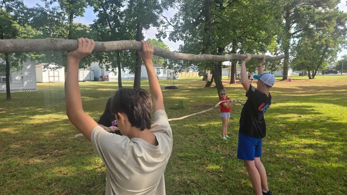 students exercising with large logs at school